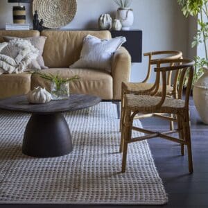 VENDELA matta XL beige elfenben från Affari of Sweden i vardagsrum med naturtoner, placerad under soffbord och stolar i rotting.