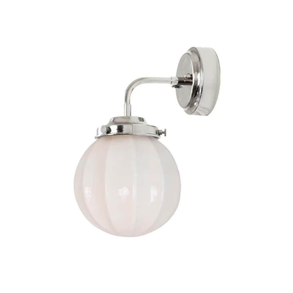 En elegant badrumslampa i förnicklad metall med runt opalglas från Strömshaga.