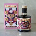 Flaska med Gridelli Balsamico Amarena bredvid dess färgglada förpackning på ett marmorbord.