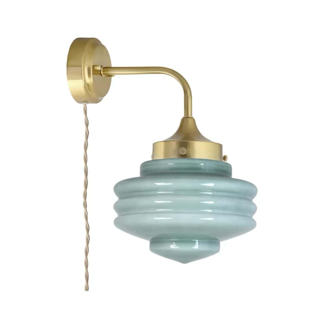 Elegant vägglampa i mässingsfinish med vackert grönt opalglas från Strömshaga, modell VALTER. Lampan har en tvinnad beige textilsladd och ett tidlöst sekelskiftesutseende.