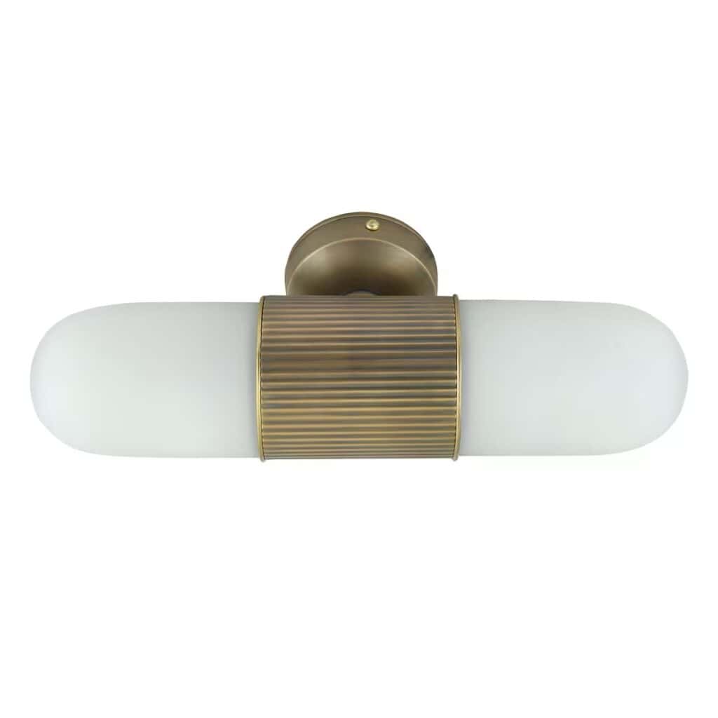 Elegant badrumslampa i antik mässing med ovalt frostat glas, sedd framifrån.