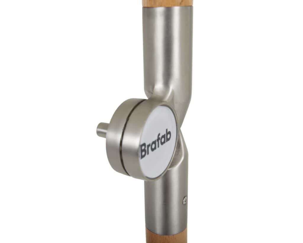 Närbild på lutningsmekanismen med Brafab-logotypen på Gatsby parasoll, monterad på trästången.