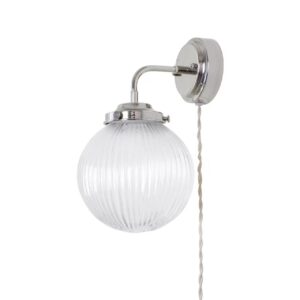 Vägglampa Eivor från Strömshaga med förnicklat fäste och räfflad, rund glaskupa, samt en tvinnad sladd för en klassisk och stilren look.