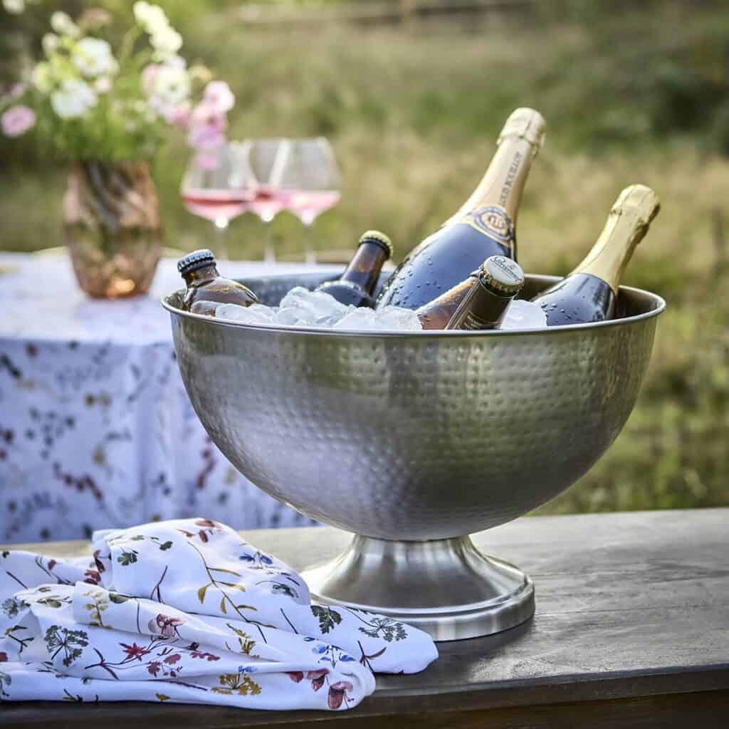CARTER champagnekylare fylld med is och flaskor, perfekt för sommarfester och middagar utomhus. Lyxig och praktisk vinkylare från Affari of Sweden.
