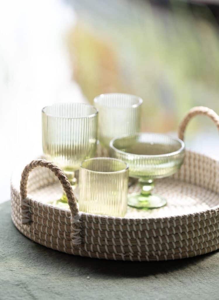 Gröna glas i korgbricka – inspiration för sommarstugeinredning med naturlig dukning och somriga detaljer.