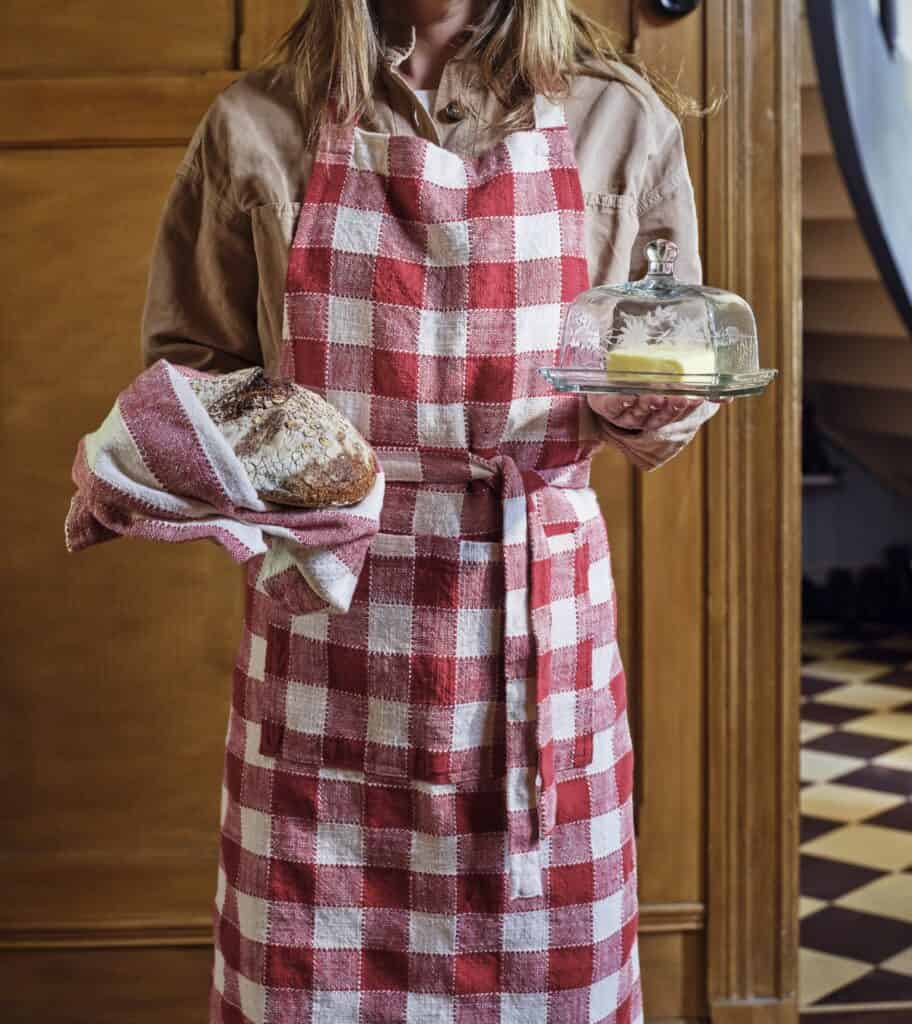 Adventsstämning hemma med rödvitt rutigt förkläde och kökstextilier i julig stil.