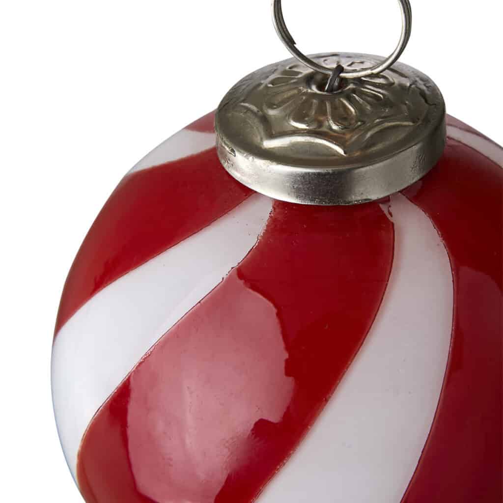 Närbild på handgjord julgranskula i glas, röd och vit rand, CIRCUS från Hemlängtan.