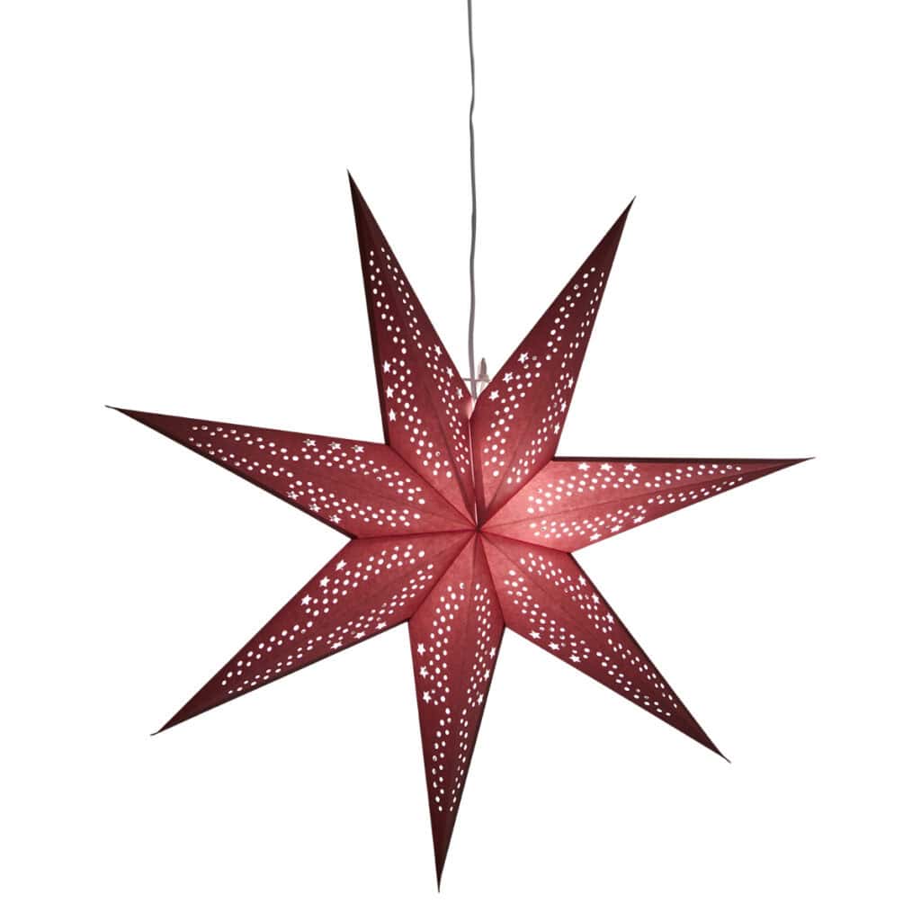 Röd julstjärna UNI i papper med hålmönster, tänd och hängande i fönster.