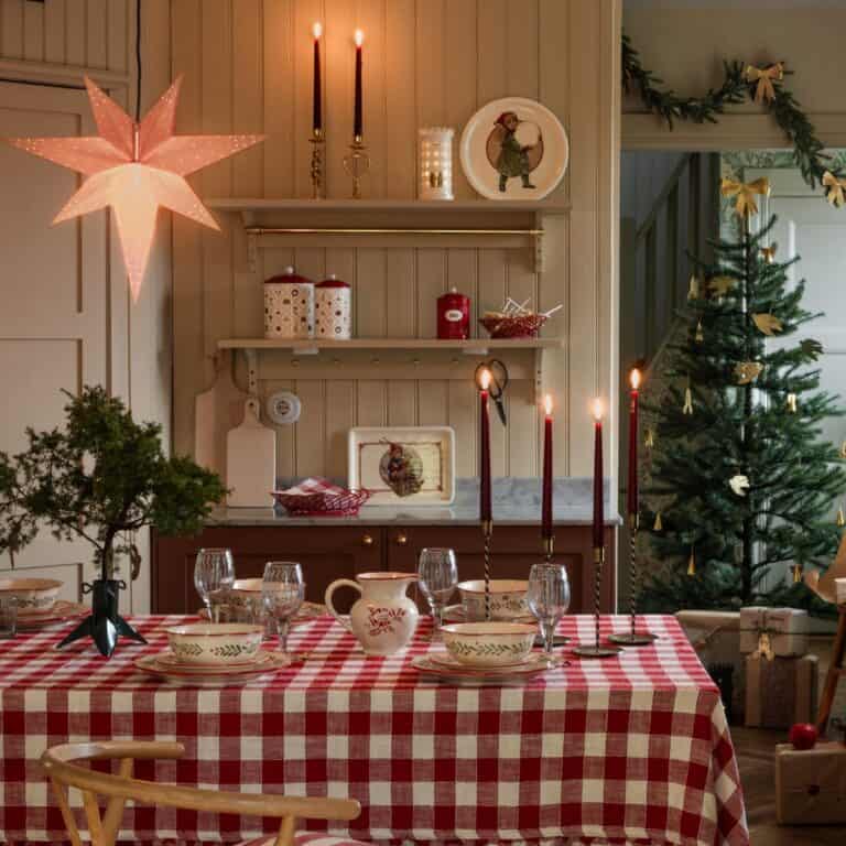 Lantlig juldukning i rödvitrutigt med mässingsljus, gran och porslin från Strömshaga – julinspiration från Hemlängtan.