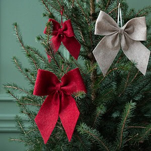 Röda rosetter i granen – juldekoration i textil från Hemlängtan.