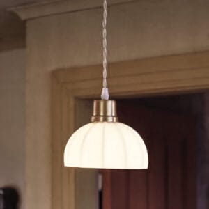 Närbild på taklampa Doris i vit opalglas med antikmässingsfäste och beige tvinnad sladd.
