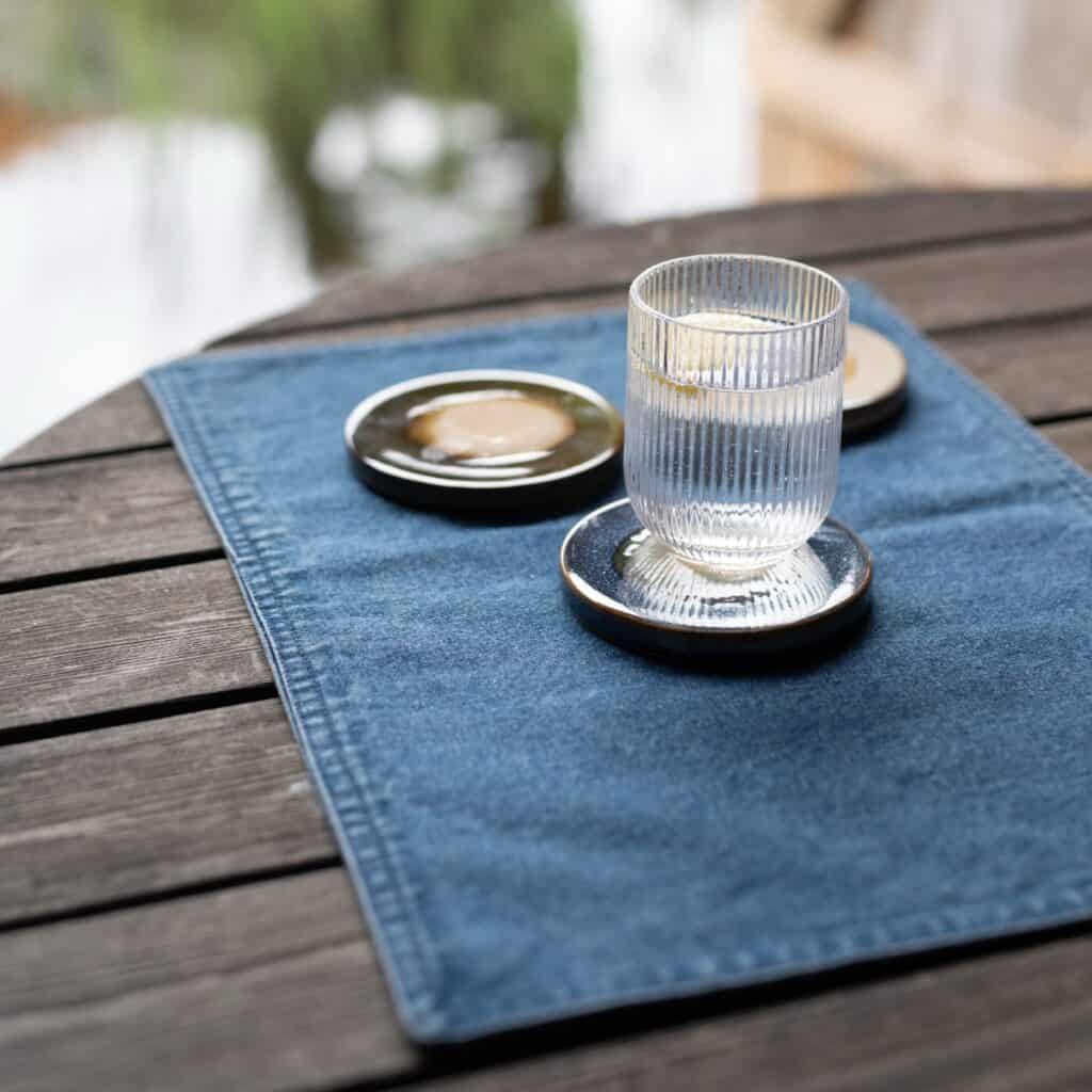 Bordstablett Deni i denim med glas och fat på dukat bord